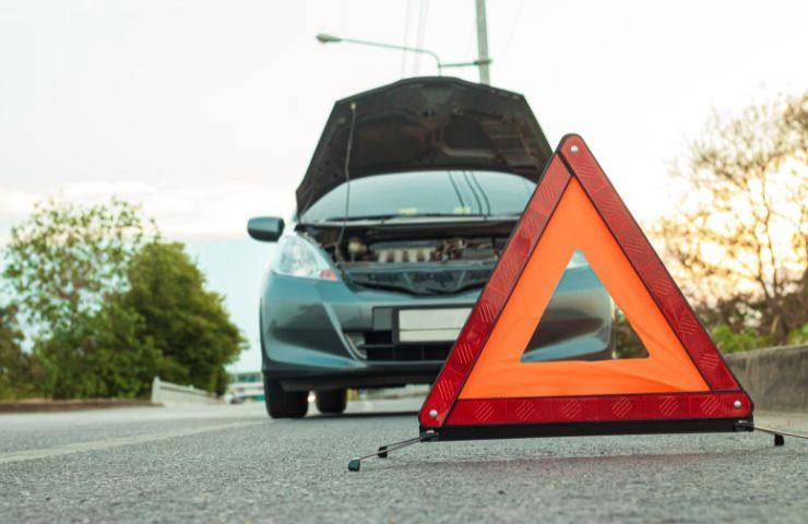 Auto ferma sulla carreggiata con il triangolo in vista